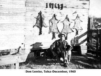 Don Lemke with one of his hounds and racoon skins drying on the barn wall.